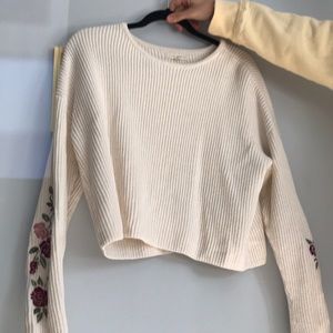 White sweater with pink and maroon roses.